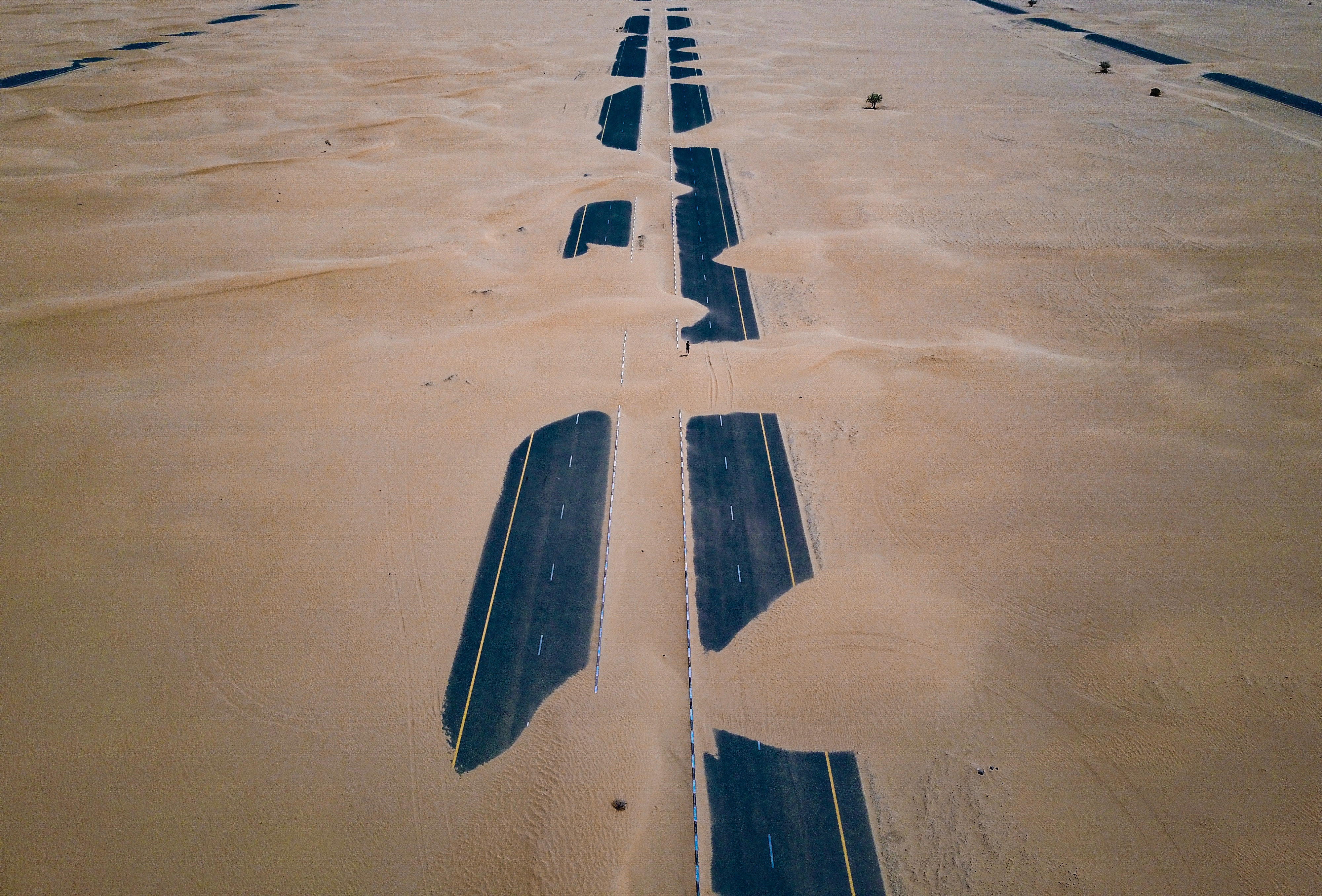 "Road partially covered by sand"